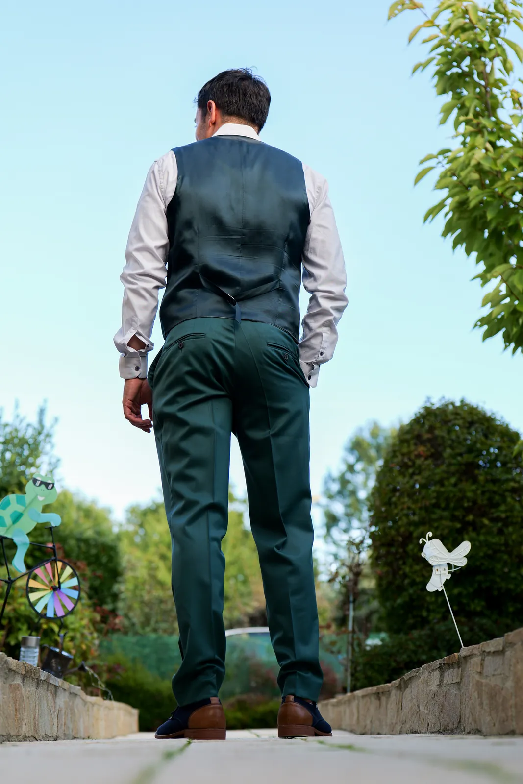 Invité en costume vu de dos, en contre-plongée dans un jardin - reportage photo NGS Editing