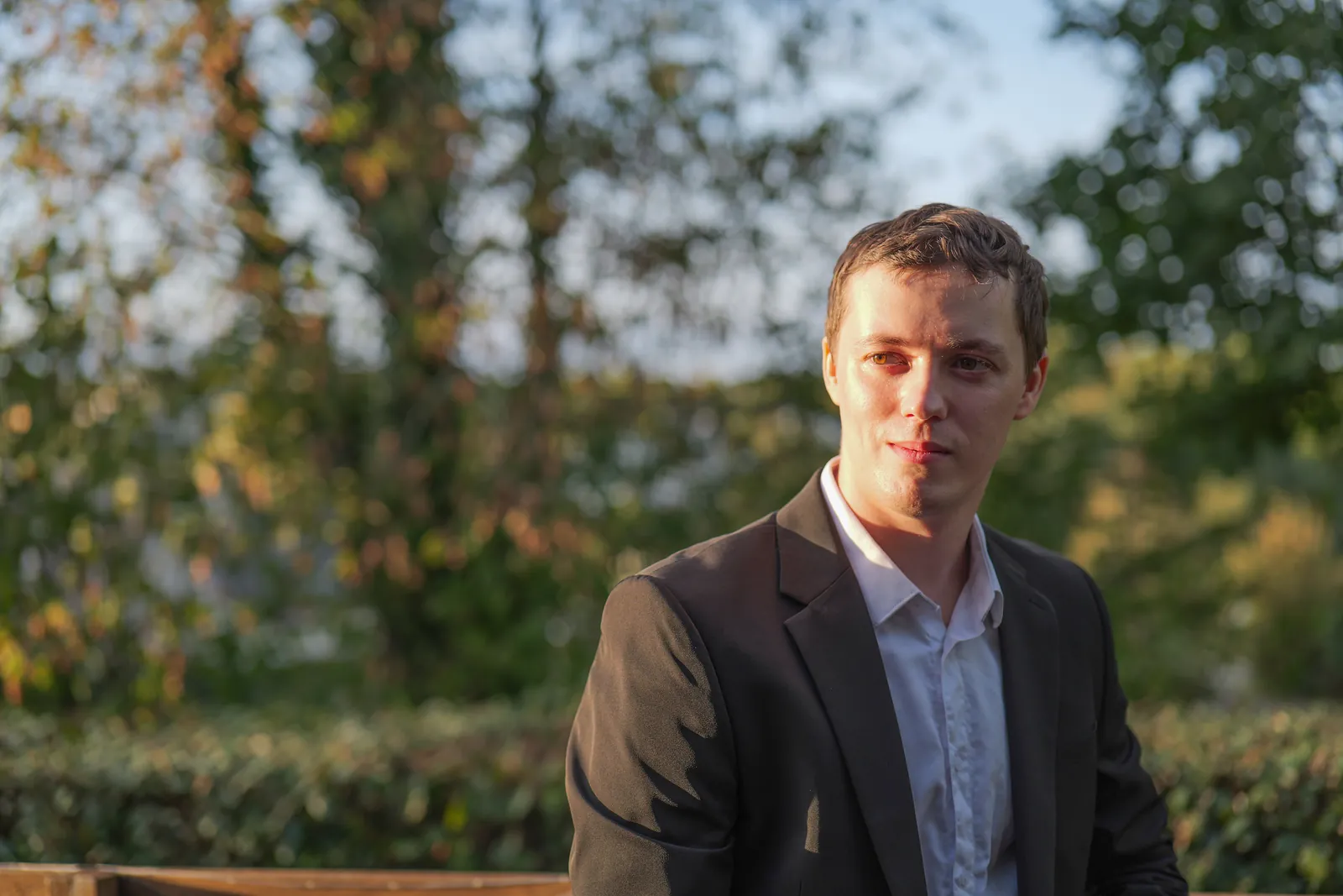 Portrait d'un invité en costume dans un jardin, fond flou - NGS Editing, photographe à Rennes