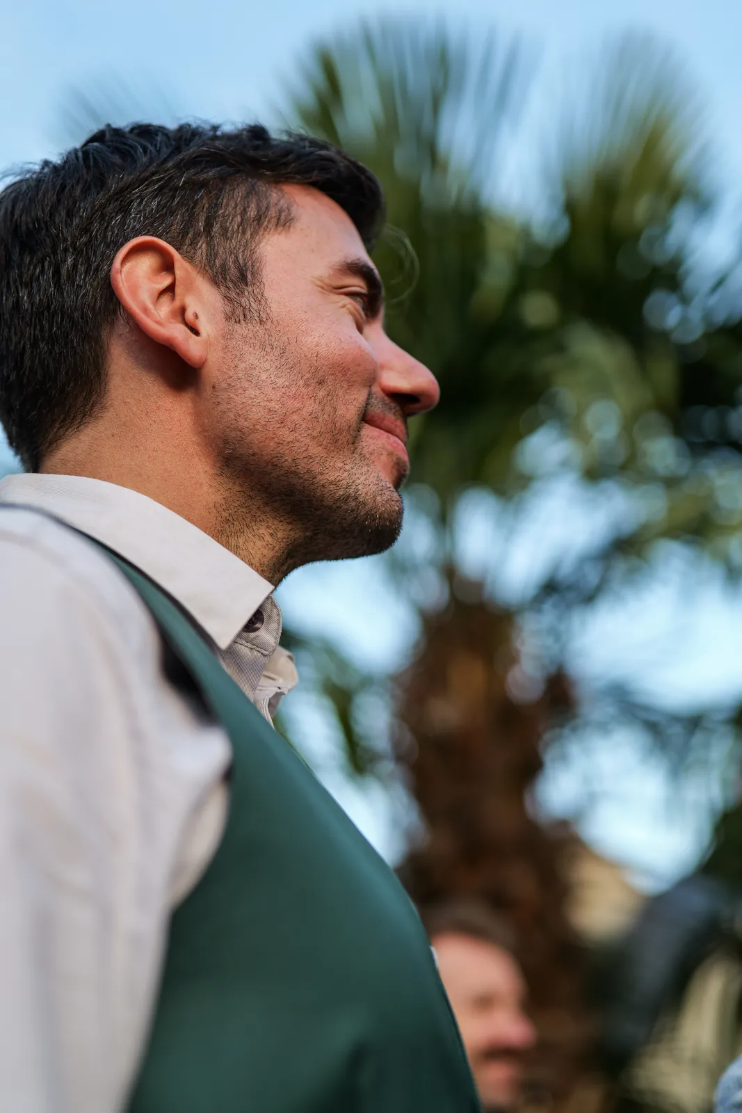 Portrait serré d'un invité souriant en gilet vert - photo d'événement NGS Editing